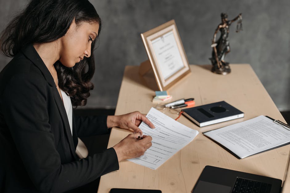 A lawyer or businesswoman reviews paperwork in an office setting.
